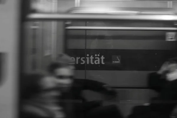 Foto skala abu-abu dari kereta bawah tanah di Jerman dengan teks di dinding dan efek kabur gerak — Stok Foto
