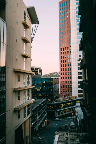 Cool view of a road and modern skyscrapers with colorful walls during the sunset — Stock Photo, Image