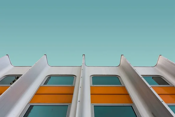 Alacsony szögű felvétel egy fehér és sárga modern épület a kék ég alatt — Stock Fotó
