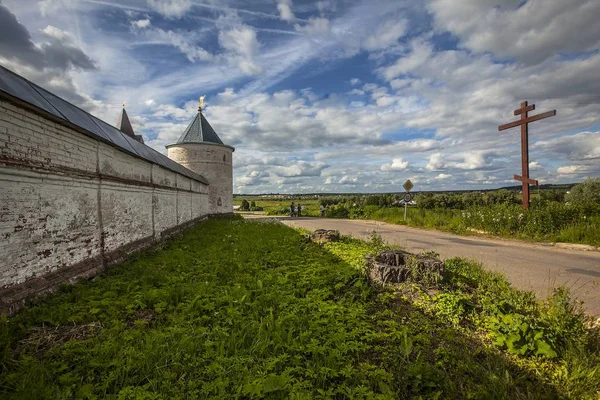 Mosteiro histórico na Rússia perto de uma paisagem verde sob o deslumbrante céu nublado — Fotografia de Stock