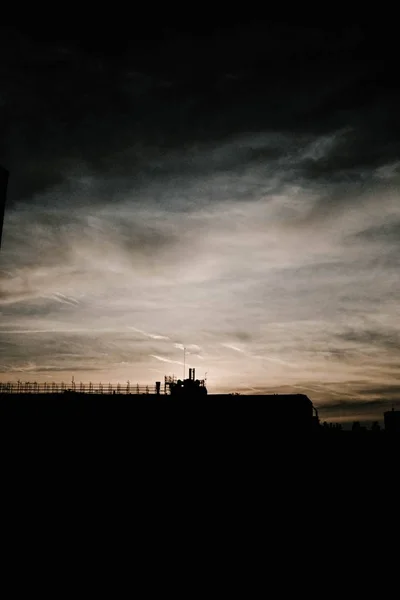 Verticale opname van het silhouet van de gebouwen onder de bewolkte lucht — Stockfoto