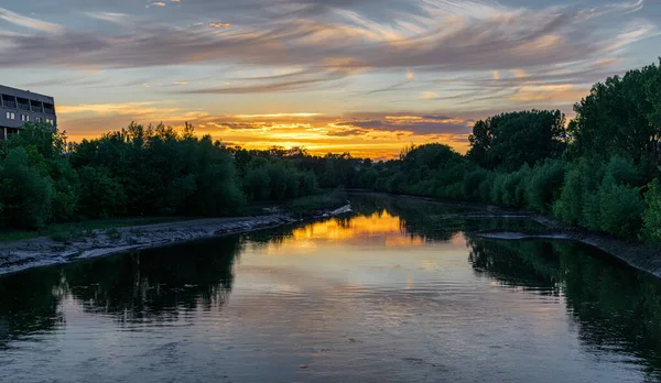 Beautiful scenery of a river with the reflection of green trees and the sunset — Stock Photo, Image