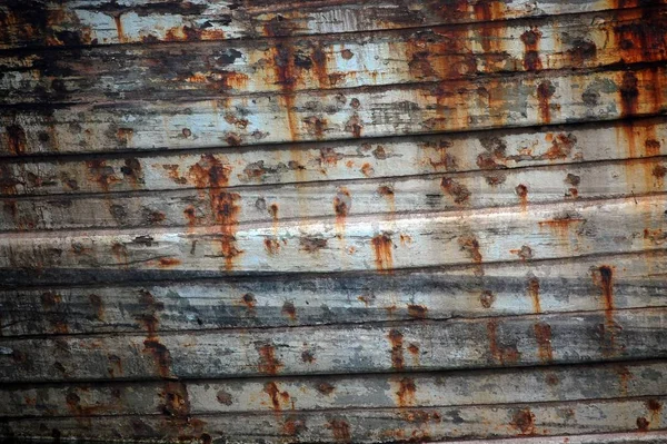 Closeup of an old rusty white wall with black spots and dirt on it