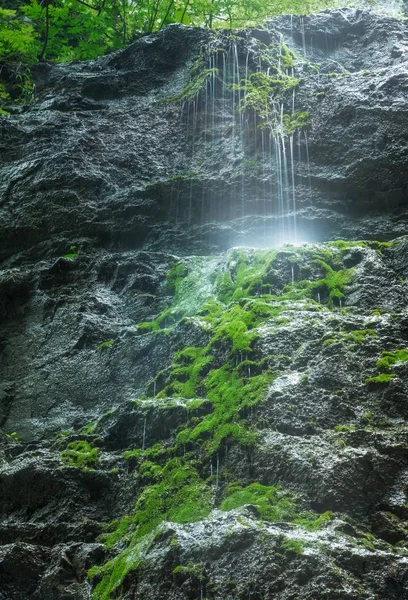 Vertikal bild av ett vattenfall omgivet av grönska och stenar i Djävulspasset i Kroatien — Stockfoto