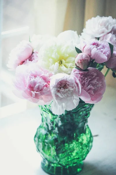 Крупный план красивых розовых и белых цветов в кристально-зеленой вазе в помещении — стоковое фото
