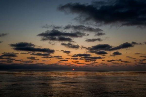Красивые пейзажи заката и формирования облаков, отражающихся в море - отлично подходит для обоев — стоковое фото