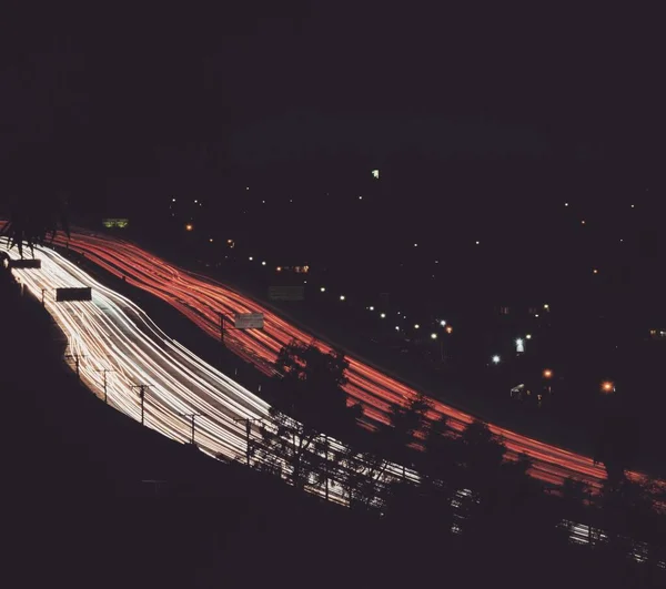 Hoge hoek opname van twee parallelle snelwegen met rode en witte lichten 's nachts — Stockfoto