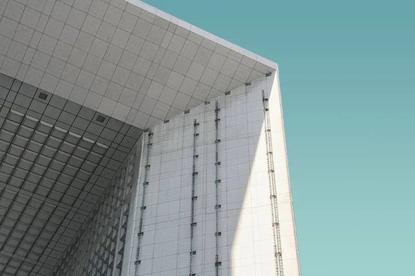 Tiro de ângulo baixo de um edifício moderno branco sob o céu azul — Fotografia de Stock