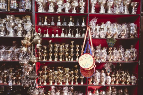Серебряные колокольчики и чашки на полке в магазине — стоковое фото