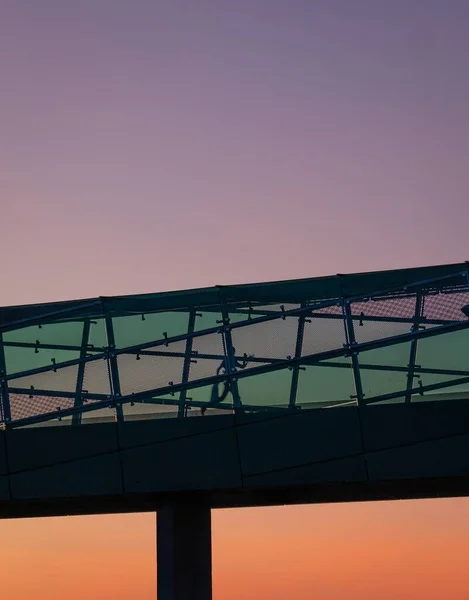 Tiro de ângulo baixo de uma estrutura de um edifício moderno abaixo do céu de pôr-do-sol — Fotografia de Stock