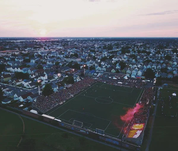 Fußballstadion in einem von Gebäuden umgebenen Viertel unter wolkenverhangenem Himmel bei Sonnenuntergang — Stockfoto