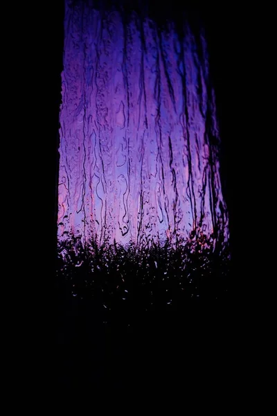 Fecho fresco de um abajur em um vidro em camadas roxo com um fundo preto — Fotografia de Stock