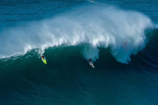Surfistas nas ondas do Oceano Atlântico em direcção à costa em Nazare, Portugal — Fotografia de Stock