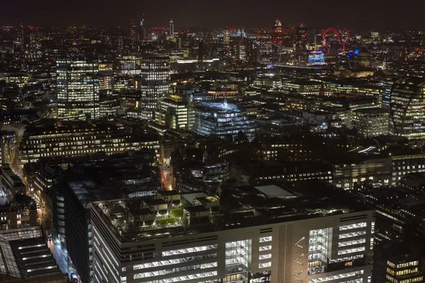 Высокий кадр современных зданий и огней под ночным небом в Лондоне от Бродгейтской башни — стоковое фото