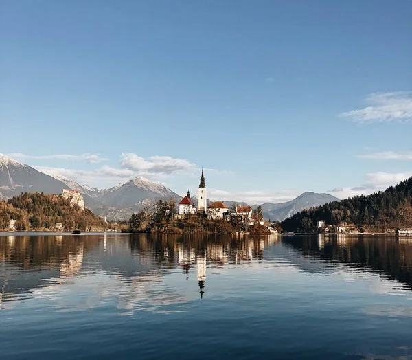 Ancien château entouré d'un paysage montagneux reflétant dans le lac — Photo