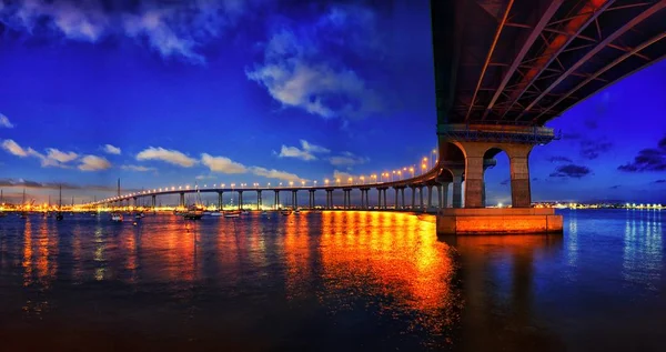 Reflejo de las luces de la ciudad en el río bajo el vibrante cielo azul durante la noche — Foto de Stock