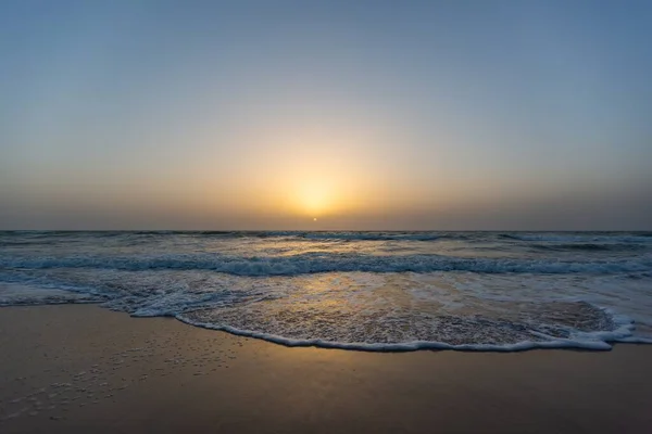 Hermosa imagen de una puesta de sol desde una playa bajo un cielo azul en Senegal — Foto de Stock
