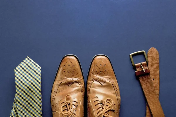 Superficie azul oscuro con zapatos. corbata y un cinturón en la parte inferior —  Fotos de Stock