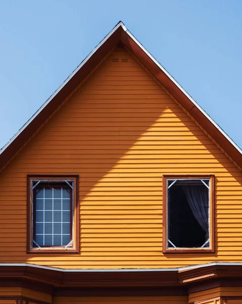 맑고 푸른 하늘 아래있는 나무로 된 오렌지 하우스의 수직 사격 — 스톡 사진