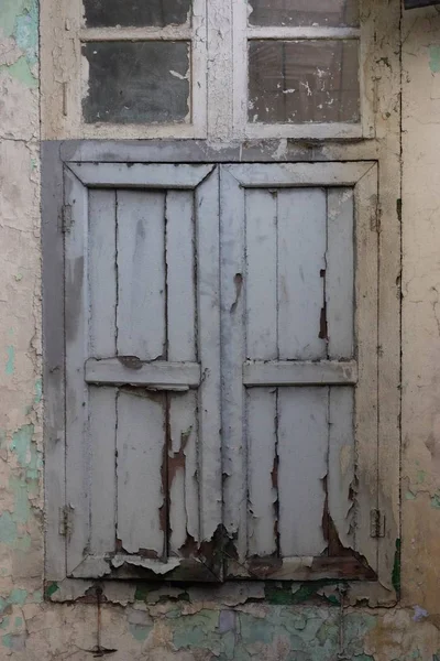 Scatto verticale di una vecchia finestra vintage in legno con persiane arrugginite — Foto Stock