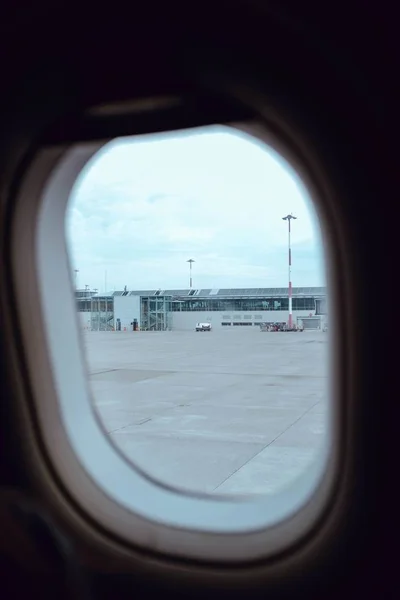 Vertical shot of an airplane window showing the world outside of the vehicle — Stock Photo, Image