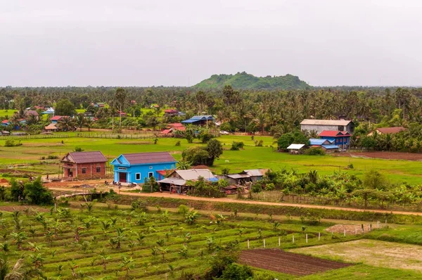 Pueblo rodeado de verdes paisajes bajo el cielo despejado en Camboya en Asia —  Fotos de Stock