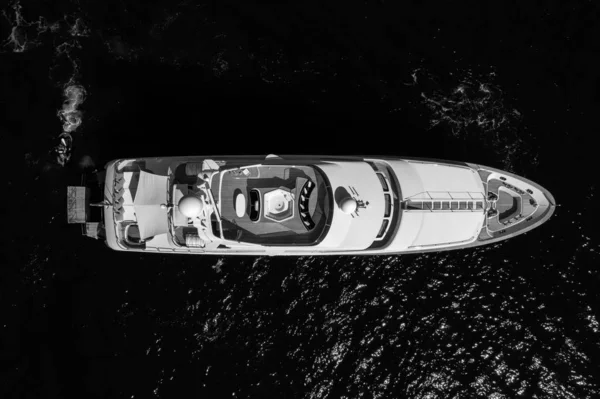 Vuelo de altura a escala de grises de un yate privado que navega en el océano —  Fotos de Stock