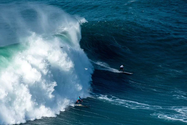 Grandes olas espumosas del Océano Atlántico cerca del municipio nazarí en Portugal y surfistas a caballo —  Fotos de Stock