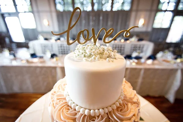背景に愛のサインがあるウェディングケーキのクローズアップショット — ストック写真