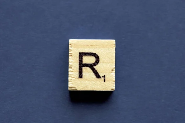 Písmeno R na dřevěné kostce ze hry pro slovní hříčku — Stock fotografie