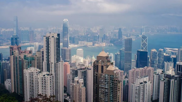 Nagy látószögű felvétel egy városról, sok magas felhőkarcolóval a felhős ég alatt Hong Kongban. — Stock Fotó