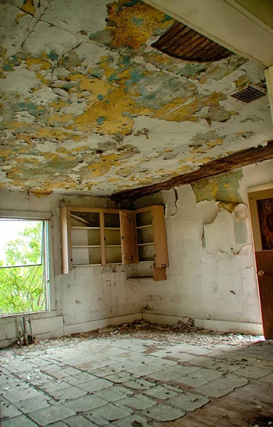 Vertical shot of an interior of an abandoned house with broken furniture and a rotten  ceiling — Stock Photo, Image