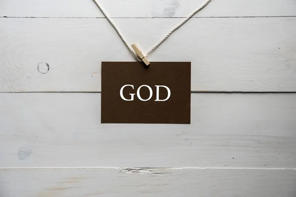 Closeup shot of a sing attached to a string with god written on it — Stock Photo, Image