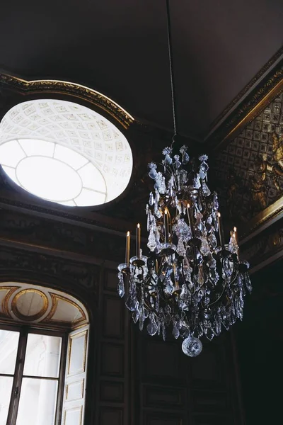 Vertical low angle shot of a beautiful crystal chandelier in an old building — Stock Photo, Image