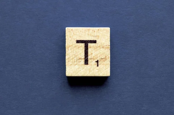 Carta T em um cubo de madeira de um jogo de tabuleiro wordplay — Fotografia de Stock