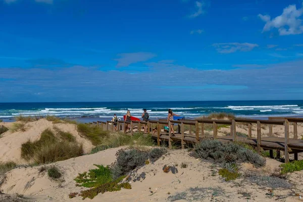Paisagem de uma praia de madeira com pessoas na praia rodeada pelo mar em Portugal — Fotografia de Stock