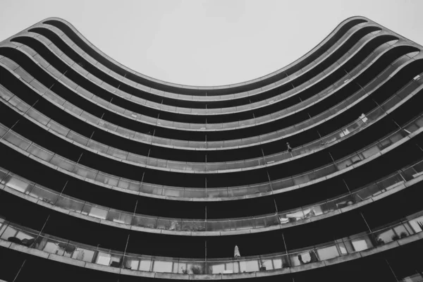 Szürke skála alacsony szögű felvétel egy modern épület kerek homlokzattal — Stock Fotó