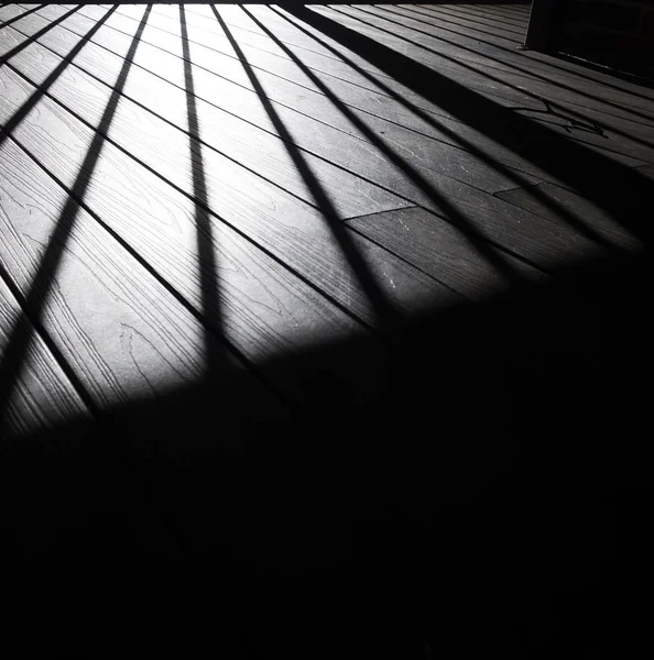 Tahta zeminde uzanan el raylarının gölgesi — Stok fotoğraf