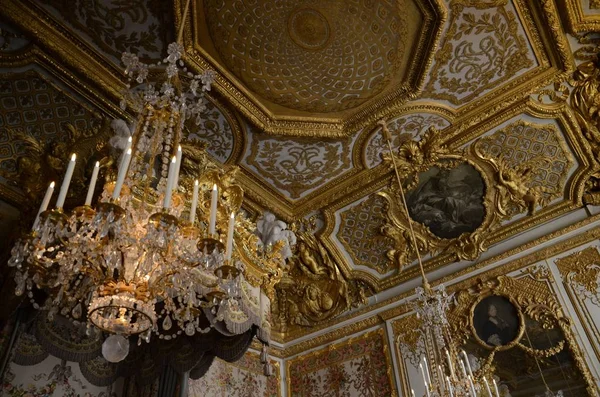Detailed picture of the ceiling covered in gold decors and pictures in the palace of Versailles — Stock Photo, Image