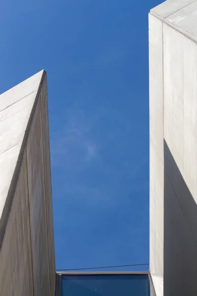 Vertical tiro de baixo ângulo de edifícios de concreto branco sob o belo céu azul — Fotografia de Stock