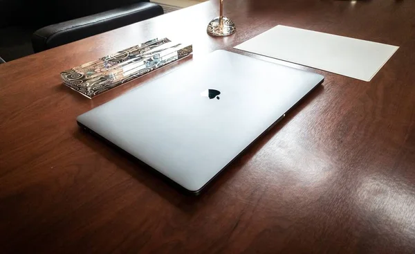 Captura de ángulo alto de un MacBook de Apple y otros objetos en una mesa de oficina de madera — Foto de Stock