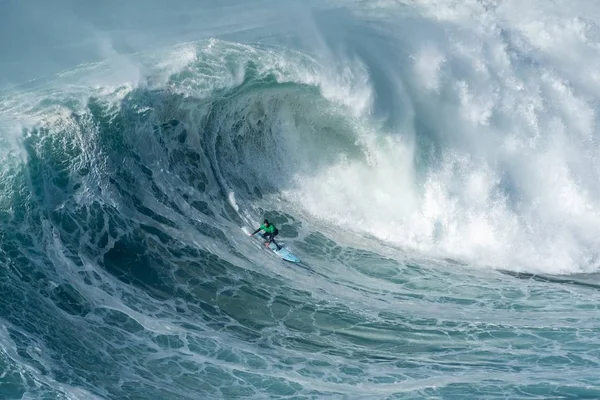 Surfista cogiendo la ola alta del espumoso Océano Atlántico en Nazare, Portugal —  Fotos de Stock