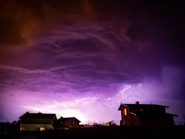 Vale com casas sobre ele sob um céu nublado durante a tempestade à noite — Fotografia de Stock