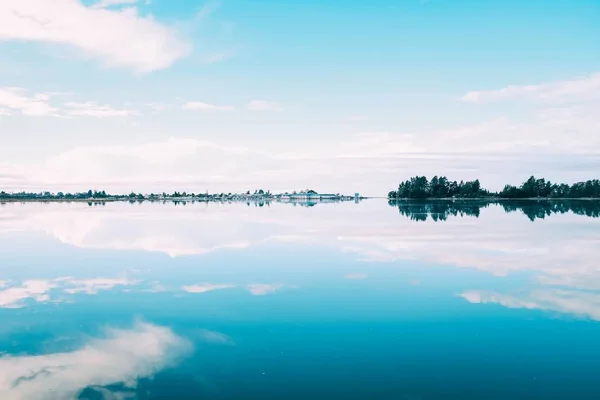 Bela paisagem de uma variedade de árvores que refletem no lago sob o céu nublado — Fotografia de Stock