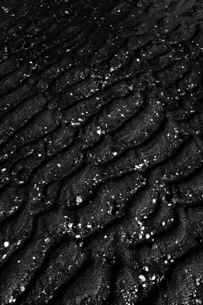 Kühler Graustufenhintergrund aus feuchtem schwarzem Sand - ideal für Hintergrund oder Tapete — Stockfoto