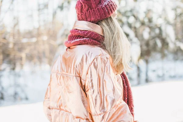 Szoros kép egy szőke nő egy kabát, kalap, és sál havas erdő homályos háttér — Stock Fotó
