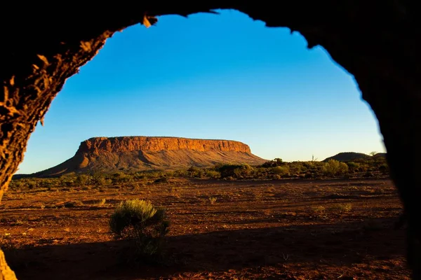 Arc rocheux avec vue sur une haute montagne, la terre et la verdure sous un ciel bleu — Photo