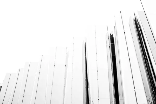 Szürke skála alacsony szögű lövés egy kerítés üveg panelek alatt a fehér ég — Stock Fotó