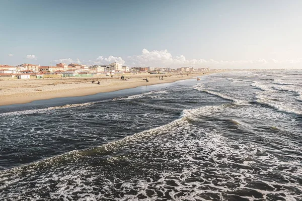 Hermoso paisaje de una gran cantidad de edificios en la orilla cerca de olas marinas locas — Foto de Stock