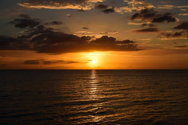 Impresionante escena de la puesta de sol en el cielo nublado sobre el océano - perfecto para un fondo de pantalla —  Fotos de Stock